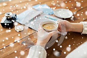 Close up of hands with coffee cup and travel stuff