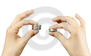 Close up. Hands compare two piles of coins of different sizes, i