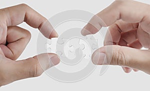 Close-up hands connecting jigsaw puzzle,  on white background