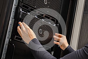 Close-up of Hands Of IT Consultant Installing Servers In Rack at Datacenter