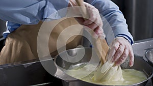 Close up for hands in cooking gloves preparing mozzarella cheese, food concept. Frame. Worker from cheese factory