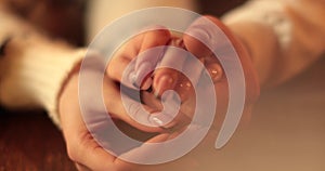 Close-up of the hands of a couple in love sitting at a table in a cafe