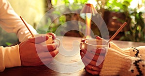 Close-up of the hands of a couple in love sitting at a table in a cafe