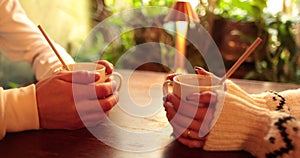 Close-up of the hands of a couple in love sitting at a table in a cafe