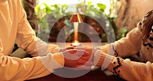 Close-up of the hands of a couple in love sitting at a table in a cafe