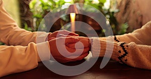 Close-up of the hands of a couple in love sitting at a table in a cafe