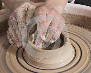 Close-up of hands of a craftsworker ceramist molding a vase in h