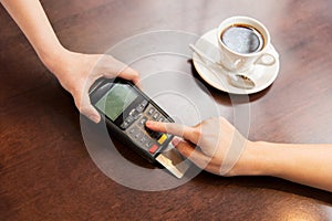 Close up of hands with credit card reader at cafe