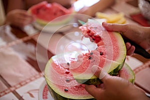 Close-up hands cutting a slice of ripe organic juicy watermelon. Food and drink concept. Raw vegan diet