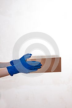 Close up hands delivery man medical gloves hold empty cardboard box on white background.