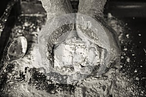 Close up  hands with dough, flour, against dark background