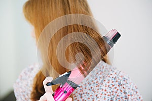 Close up of hands drying woman hair with equipment.