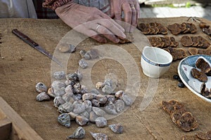 Close-up of the hands of an elderly woman preparing dried figs