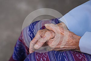 Close-up of hands elderly woman`s joined together. Focus on hands wrinkled skin. Space for text. Concept of aged people