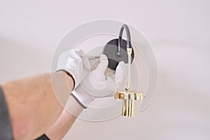 Close-up hands of electrician installing wall lamp