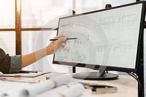 Close up hands of an engineer working and checking blueprints on computer. Engineer pointing for check planning project on compute