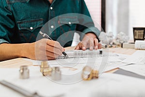 Close up hands of an engineer working and checking on blueprints. Engineer planning project on paperwork with equipment