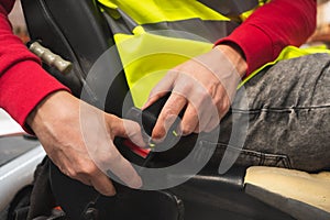 Close-up of hands fastening the seat belt of a forklift