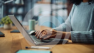 Close Up on Hands of a Female Specialist Working on Laptop Computer at Cozy Home Living Room while