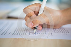 Close up of hands filling out employment application form with a pen. photo