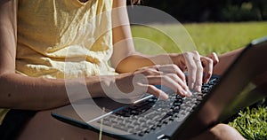 Close up hands of freelance woman working outdoor with laptop typing on keyboard