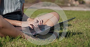 Close up hands of freelance woman working outdoor with laptop typing on keyboard