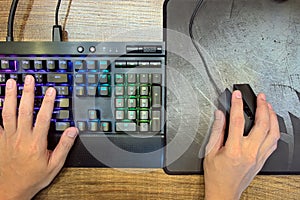 Hands of Gamer who use Mechanical Gaming Keyboard and Gaming Mouse for play game on Computer PC Desktop