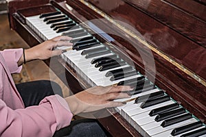Close-up of the hands of a girl playing the piano. Teenage girl learns to play the piano