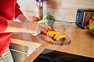 Close-up of the hands of a girl preparing a salad according to a video recipe. Cooking courses online. Video recipes and