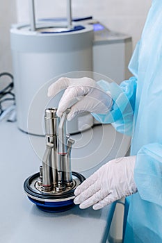 Close-up hands with gloves in the places medical autoclave for sterilising surgical and dental instruments