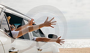 Happy family sitting in the car waving hands travel outside car windows