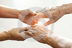 Close up hands of helping hands elderly home care. Mother and daughter