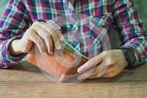 Close up of hands holding brown leather wallet