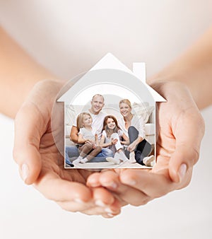 Close up of hands holding house shape with family