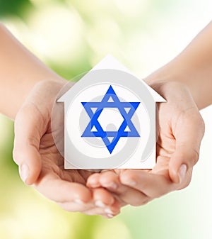 Close up of hands holding house with star of david