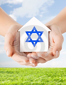 Close up of hands holding house with star of david