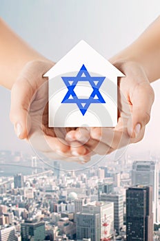 Close up of hands holding house with star of david