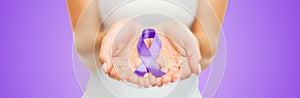 Close up of hands holding purple awareness ribbon photo