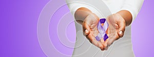 Close up of hands holding purple awareness ribbon photo