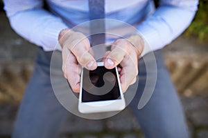 Close up of hands holding smartphone. Businessman scrolling on smartphone.