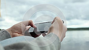 Close up hands holding and using mobile smart phone outdoor