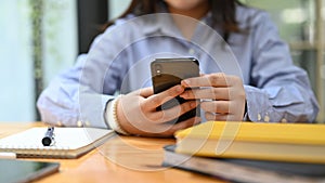 Close-up hands image, A businesswoman using her smartphone at her office desk