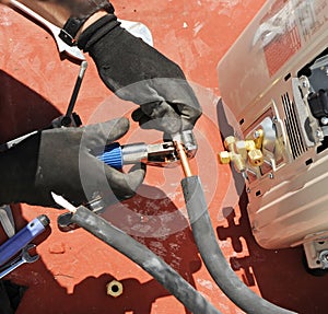 Close-up of the hands of an installer technician cutting with a special tool the copper pipes for the assembly of a new air condit