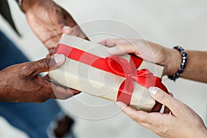 Close up hands of interracial couple . Man giving Valentine's day gift to his woman,girlfriend or wife