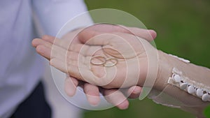 Close-up hands of interracial young couple with wedding rings in palm. Unrecognizable Middle Eastern woman and Caucasian