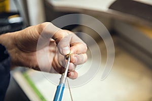 Close up hands of jeweller, goldsmiths making of golden ring with gemstone using professional tools.