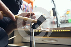 Close up hands of jeweller, goldsmiths making of golden ring with gemstone using professional tools.