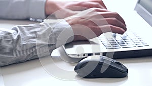 Close-up of hands and keyboard. Clerk working on laptop.