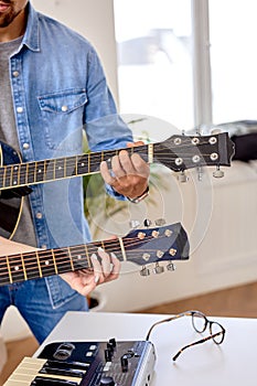 Close-up hands, Learning to play the guitar. Male teacher explains to female student