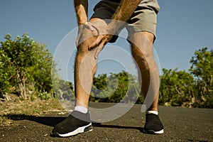 Close up hands and legs of sport man injured touching his knee in pain suffering physical problem or some injury during running
